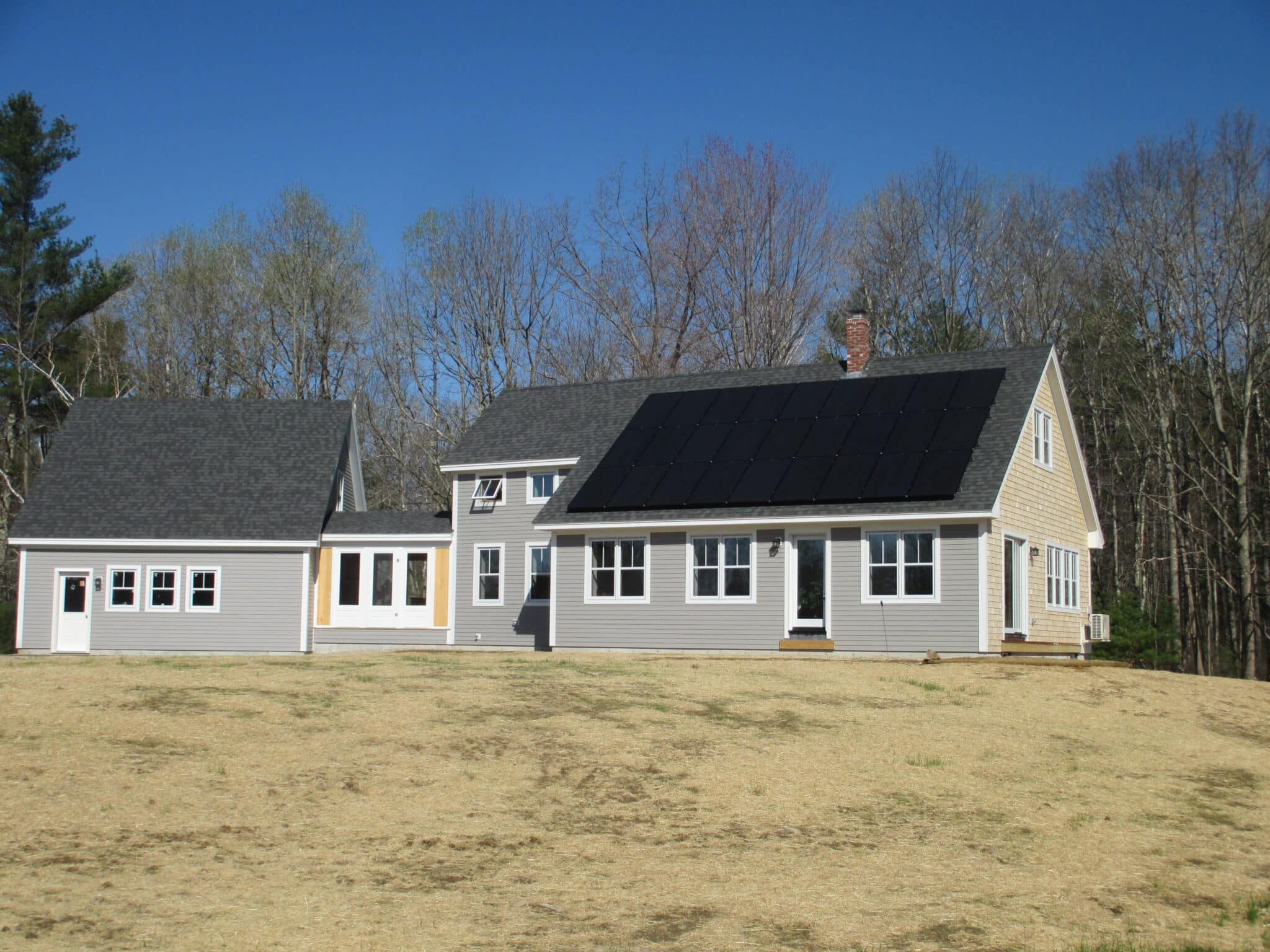 A newly built home in Maine with solar panels on the roof, representing solar-ready design and energy-efficient construction.