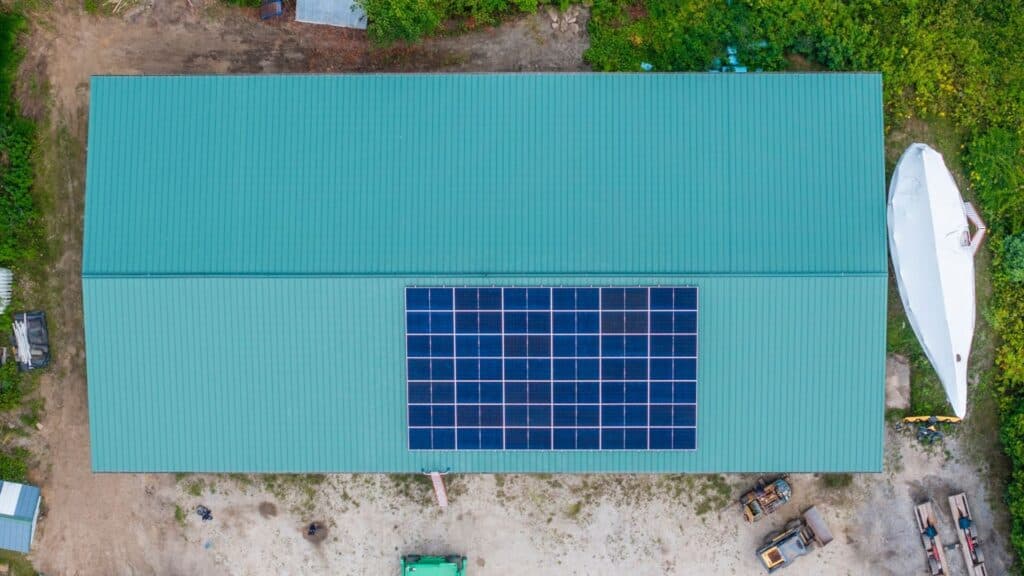 Aerial view of solar panels installed on a standing seam metal roof in Maine.